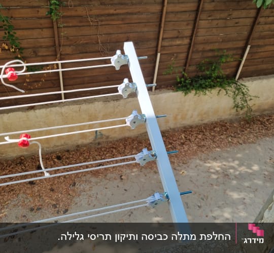 מתקן כביסה עם חוטים ומחברים על רקע גדר עץ